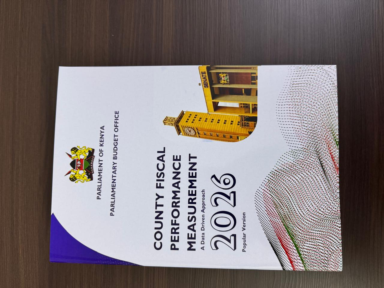Printed report cover titled County Fiscal Performance Measurement 2026 from the Parliamentary Budget Office, Parliament of Kenya.